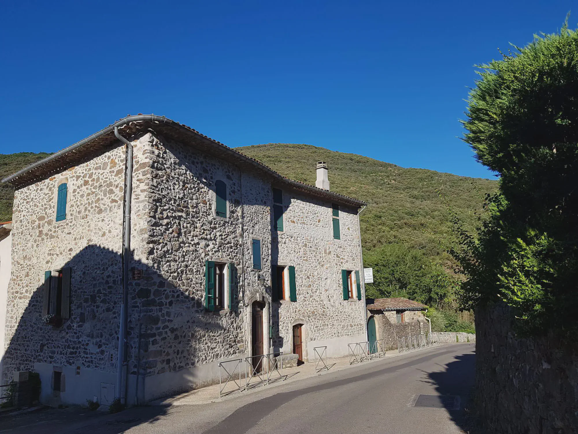 La maison cévenole en pierre, aux volets vert foncé